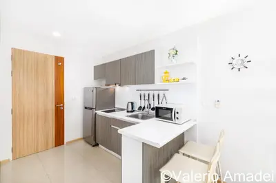 a kitchen with a refrigerator and a microwave at Ozone Condotel Kata Beach by PHR in Kata Beach