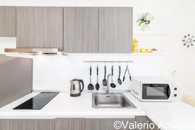a white kitchen with a sink and a microwave at Ozone Condotel Kata Beach by PHR in Kata Beach