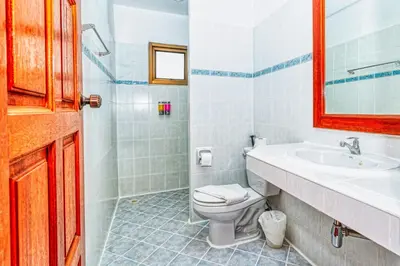 a bathroom with a toilet and a sink and a mirror at Sai Rougn Residence - SHA Extra Plus in Patong Beach