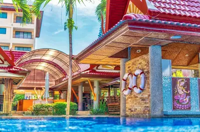 a resort with a swimming pool in front of a building at Sai Rougn Residence - SHA Extra Plus in Patong Beach