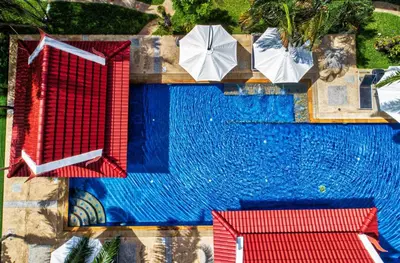 an overhead view of a swimming pool with umbrellas at Sai Rougn Residence - SHA Extra Plus in Patong Beach
