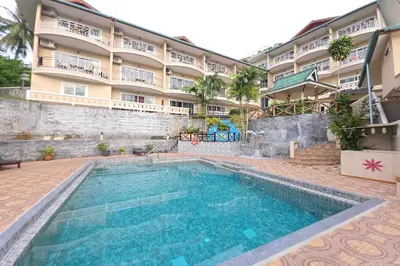 a swimming pool in front of a hotel at Patong Rai Rom Yen Resort SHA in Patong Beach