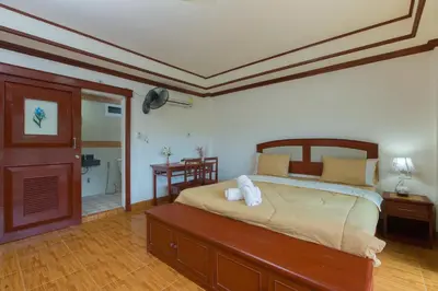 a bedroom with a large bed and a bathroom at Patong Rai Rom Yen Resort SHA in Patong Beach