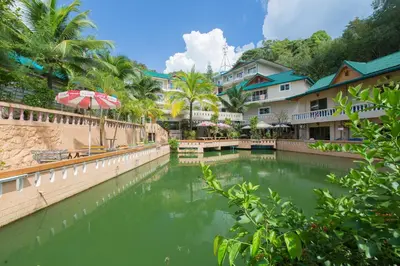 a pool of water in front of some buildings at Patong Rai Rom Yen Resort SHA in Patong Beach