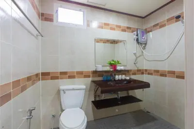 a bathroom with a toilet and a sink at Patong Rai Rom Yen Resort SHA in Patong Beach