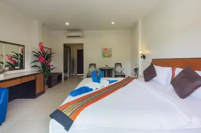 a large bedroom with a large white bed in a room at Kasemsuk Hotel Karon in Karon Beach