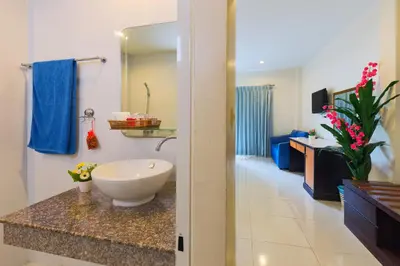 a bathroom with a white sink and a bathroom with at Kasemsuk Hotel Karon in Karon Beach