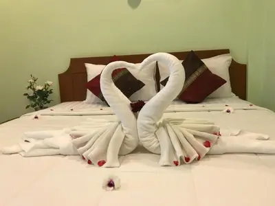 a bed with two swans made out of towels at Kasemsuk Hotel Karon in Karon Beach