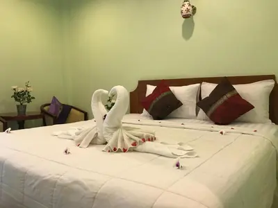 a bed with two swans made out of towels at Kasemsuk Hotel Karon in Karon Beach