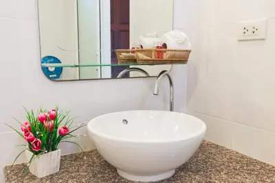 a bathroom with a white sink and a mirror at Kasemsuk Hotel Karon in Karon Beach
