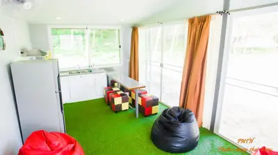 a kitchen with green flooring and a room with a window at Phuket Muay Thai House in Chalong