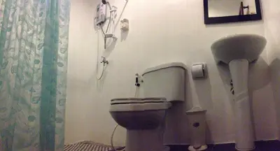 a bathroom with a toilet with a phone on the wall at Phuket Muay Thai House in Chalong