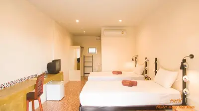 a hotel room with two beds and a tv at Phuket Muay Thai House in Chalong
