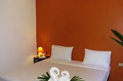 a bedroom with a bed with two towels at Hacienda Phuket, Patong in Patong Beach