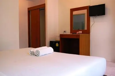 a hotel room with a bed with two towels on it at Hacienda Phuket, Patong in Patong Beach