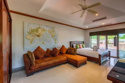 a bedroom with a couch and a bed and a map at Amber Pool Villa Your private slice of paradise in Rawai Beach