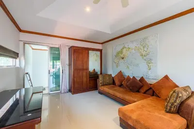 a living room with a couch and a map on the wall at Amber Pool Villa Your private slice of paradise in Rawai Beach