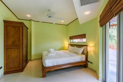 a bedroom with green walls and a bed with a teddy bear on it at Amber Pool Villa Your private slice of paradise in Rawai Beach