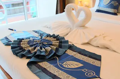 two white swans are sitting on a table at Good Nice Hotel in Patong Beach