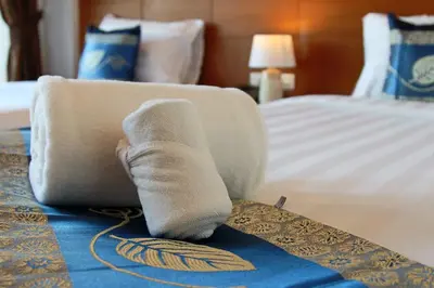 a pair of socks on a bed in a hotel room at Good Nice Hotel in Patong Beach