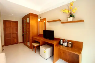 a room with a desk with a television on it at Good Nice Hotel in Patong Beach