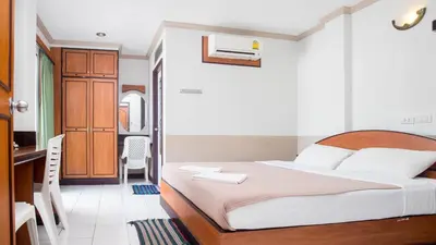 a bedroom with a bed and a desk and a kitchen at DJ House ดีเจ เฮ้าท์ป่าตอง in Patong Beach