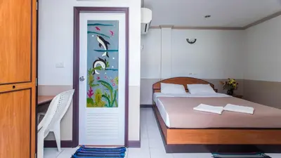 a bedroom with a bed and a door with a painting at DJ House ดีเจ เฮ้าท์ป่าตอง in Patong Beach