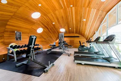 a gym with a wooden ceiling and tread machines at Emerald Terrace Patong in Patong Beach