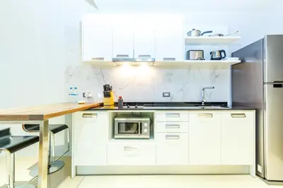 a kitchen with white cabinets and a stainless steel refrigerator at Emerald Terrace Patong in Patong Beach