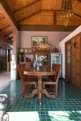 a dining room with a wooden table and chairs at West Key Kamala Villa in Kamala Beach