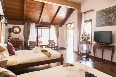 a large room with two beds and a television at West Key Kamala Villa in Kamala Beach