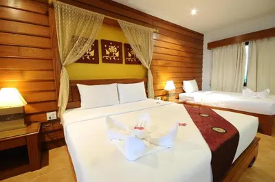 a hotel room with two beds with white sheets at Bel Aire Patong in Patong Beach