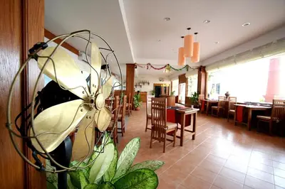 a restaurant with a plant in the middle of a room at Bel Aire Patong in Patong Beach