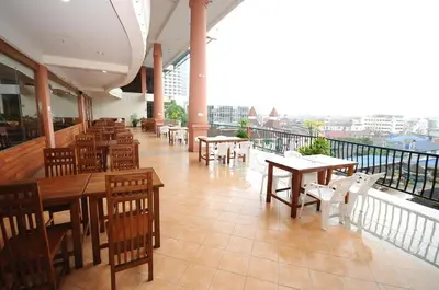 a restaurant with tables and chairs and a balcony at Bel Aire Patong in Patong Beach