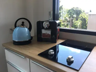 a kitchen counter with a tea kettle and a window at Baan Andaman Sea Surf in Patong Beach
