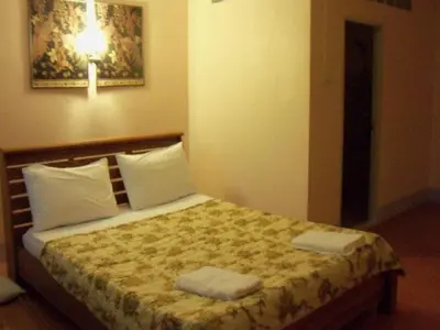 a bedroom with a bed with two towels on it at D's Corner & Guesthouse in Phuket Town