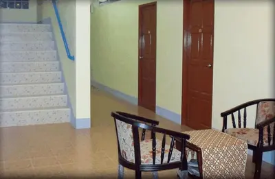 a room with two chairs and a stairway with stairs at D's Corner & Guesthouse in Phuket Town