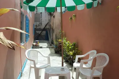 a group of chairs and an umbrella on a patio at D's Corner & Guesthouse in Phuket Town