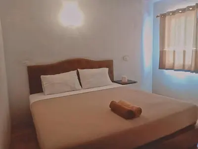 a bedroom with a bed with a wooden object on it at Boodsarin Hotel in Ko Yao Yai