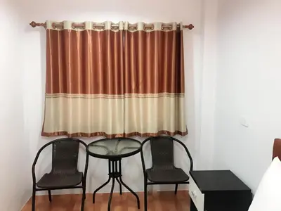 a table and two chairs in front of a curtain at Boodsarin Hotel in Ko Yao Yai