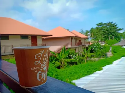 a cup of coffee sitting on top of a table at Boodsarin Hotel in Ko Yao Yai