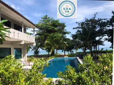 a villa with a swimming pool in front of a house at Rimlay Bungalow in Nai Yang Beach