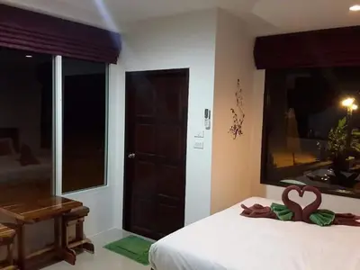 a bedroom with a bed with a heart decoration on it at Rimlay Bungalow in Nai Yang Beach