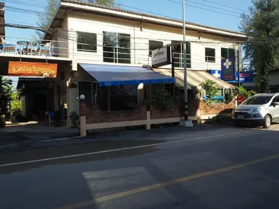 a building with a blue awning on the side of a street at Rimlay Bungalow in Nai Yang Beach