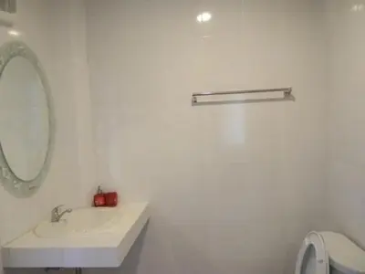 a white bathroom with a sink and a mirror at Rimlay Bungalow in Nai Yang Beach