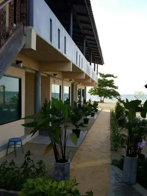 a building with a row of plants in front of it at Rimlay Bungalow in Nai Yang Beach