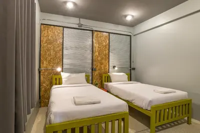 two beds in a room with two windows at Sanim Hostel in Ao Nang Beach