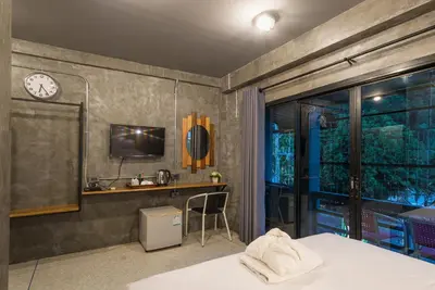 a bedroom with a desk and a clock on the wall at Sanim Hostel in Ao Nang Beach