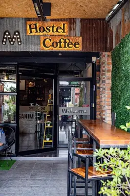 a restaurant with a wooden table and chairs in front of it at Sanim Hostel in Ao Nang Beach