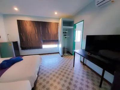 a bedroom with a bed and a desk and a television at 2 Home in Chalong